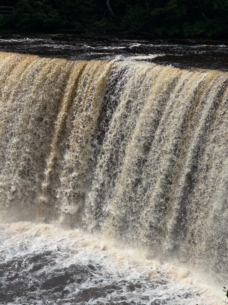 Close-up of amber-colored water pouring over Upper Tahquamenon Falls