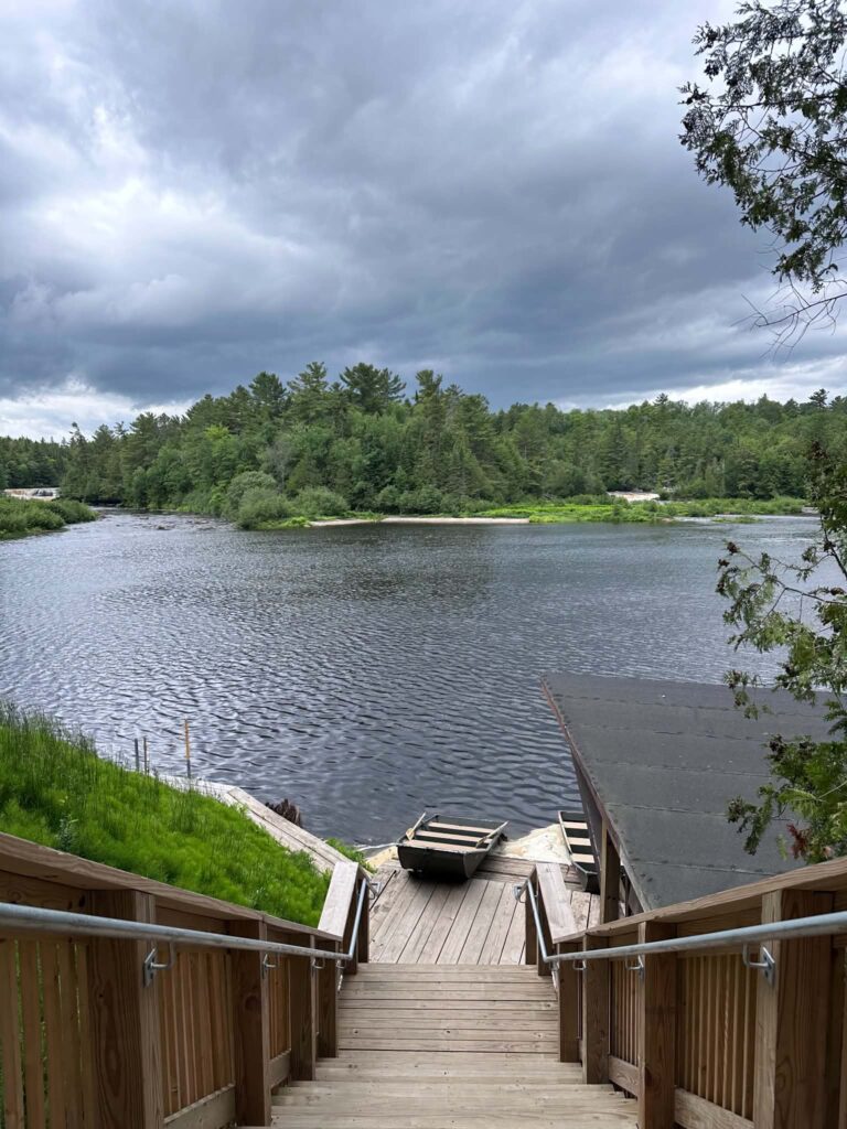Wooden boardwalk stairs descending toward the Tahquamenon River at the Lower Falls viewing area