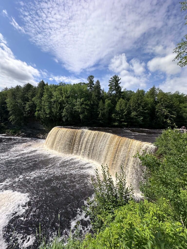 Panoramic overlook of Upper Tahquamenon Falls under blue summer skies
