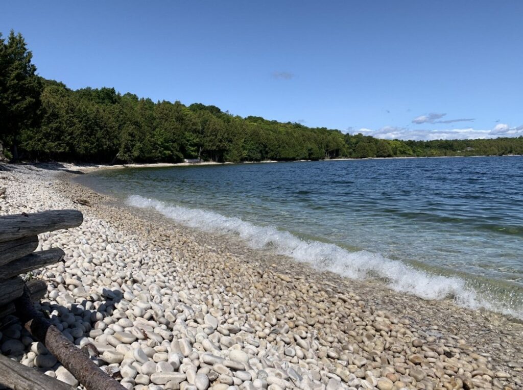 The beach is made of smooth limestone stones instead of sand — beautiful to look at, and genuinely slippery underfoot.