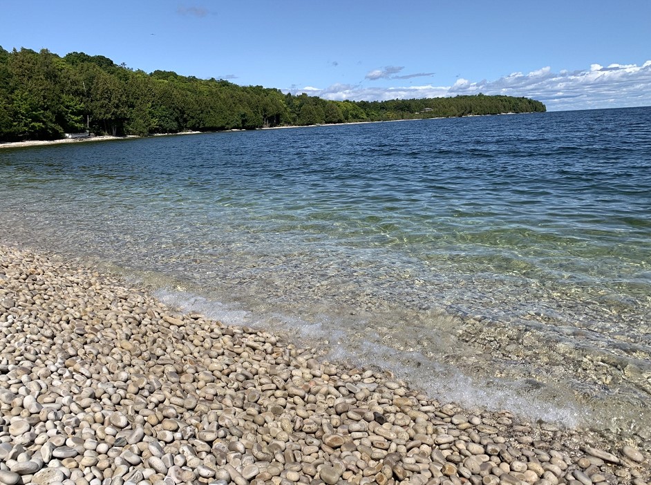 Up close, the stones are rounded and pale — and protected, so they stay on the beach where they belong.