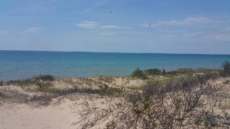 The northern Michigan shoreline near Petoskey — white sand dunes and that signature turquoise water.