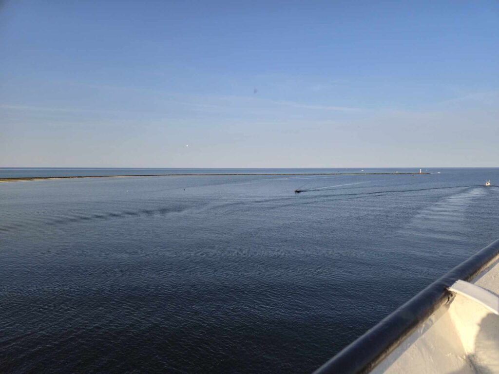 The SS Badger leaving Ludington — the pier lighthouse shrinks behind as Lake Michigan opens up ahead. This is the crossing that changes how you think about the Circle Tour.