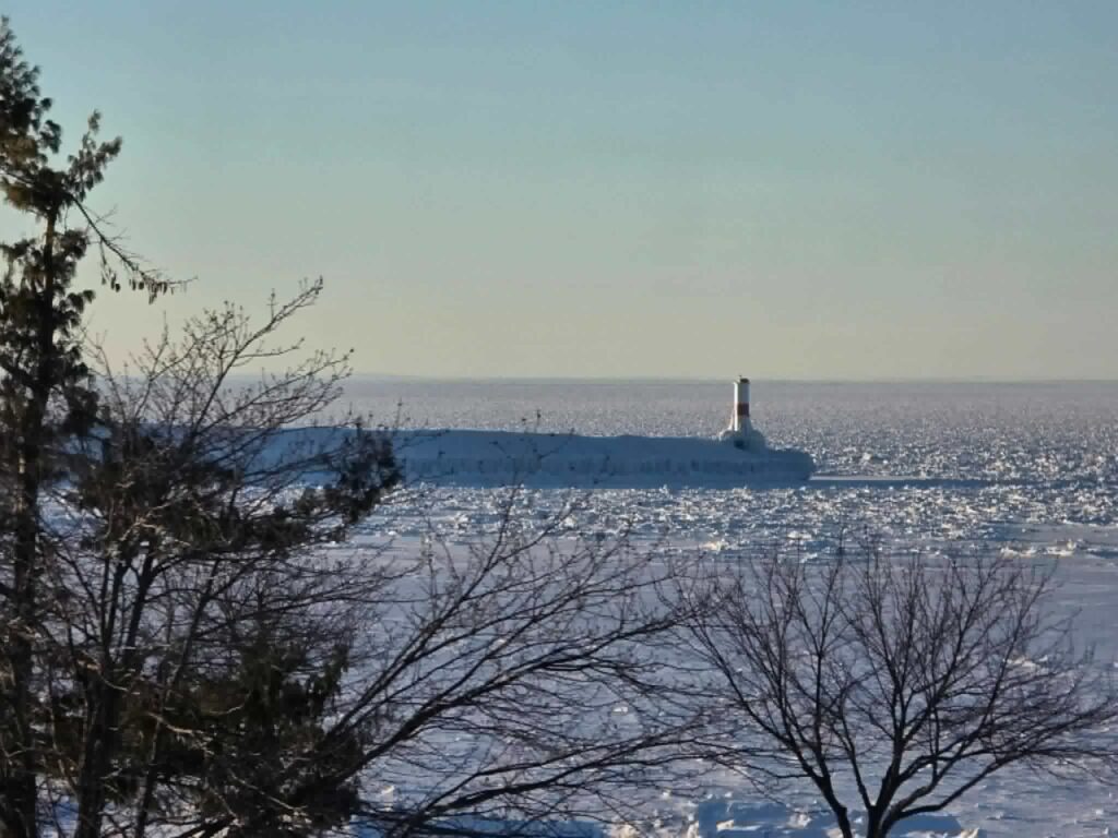 Lake Michigan in winter — the lake freezes dramatically and the lighthouses ice over completely. The beach towns are quieter but still remarkable