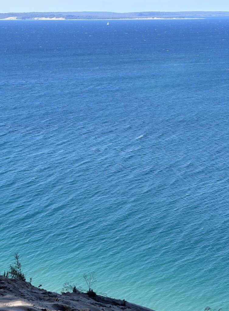 Pyramid Point overlook at Sleeping Bear Dunes — looking straight down 200 feet to turquoise Lake Michigan, with the Sleeping Bear Dunes visible on the horizon