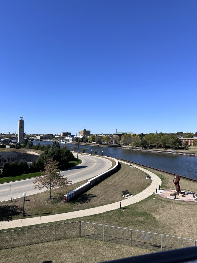 Manitowoc Wisconsin riverwalk bear sculpture and downtown skyline viewed from SS Badger upper deck arriving Lake Michigan ferry fall