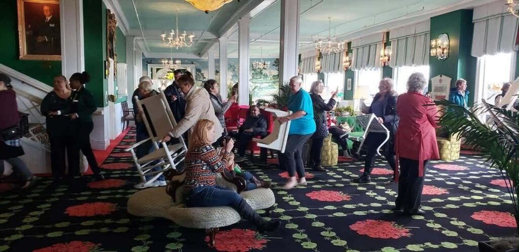 The grand hotel and their last guests bringing in the chairs from the grand porch for its seasonal closing the end of October